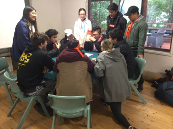 A group of students completing a group task at leadership camp grouped together at a desk.